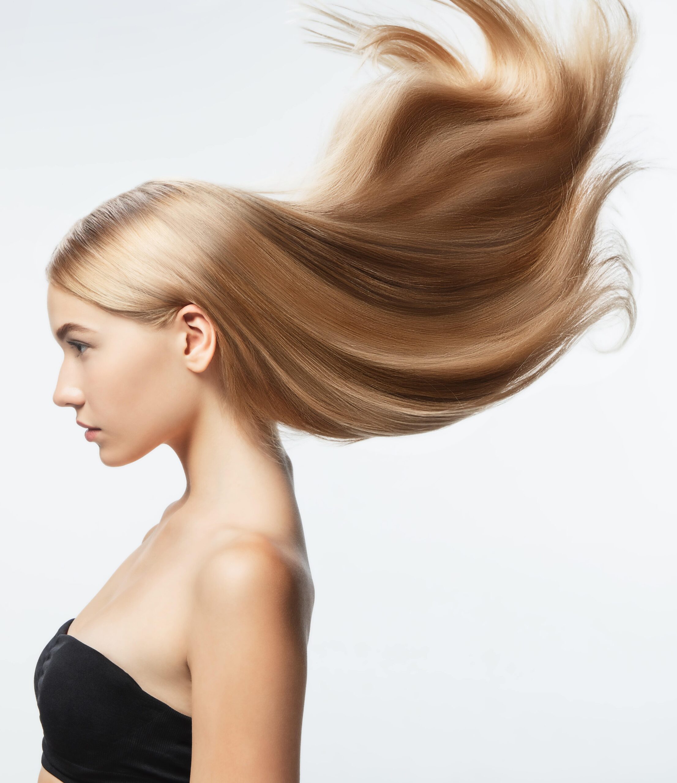 schönes-model-mit-langem-glatt-fliegendem-blondem-Haar-isoliert-weißem-Studio-Hintergrund-junges-kaukasisches-model-mit-gepflegter-Haut-Haar-blasender-Luft-min