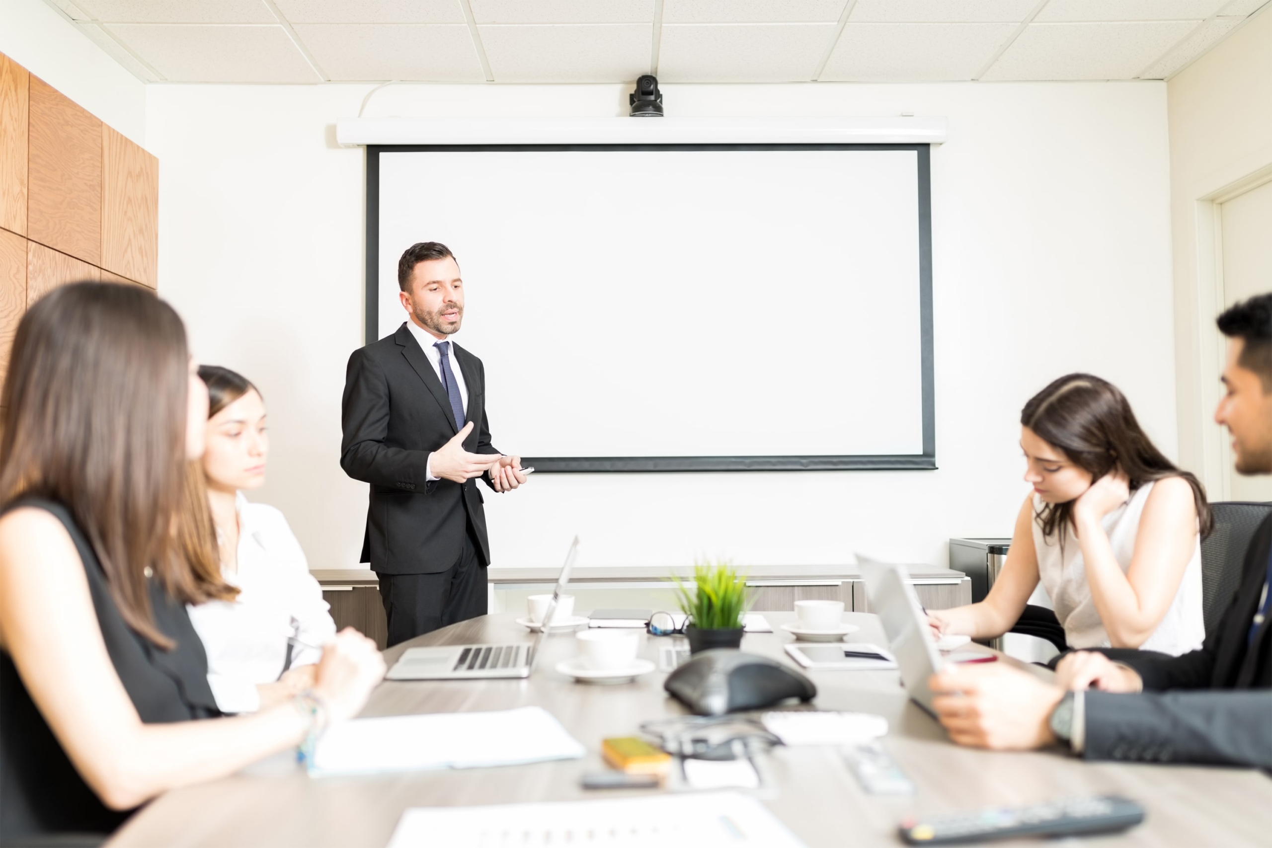 confident-mid-adult-businessman-giving-presentation-colleagues-boardroo7m-min