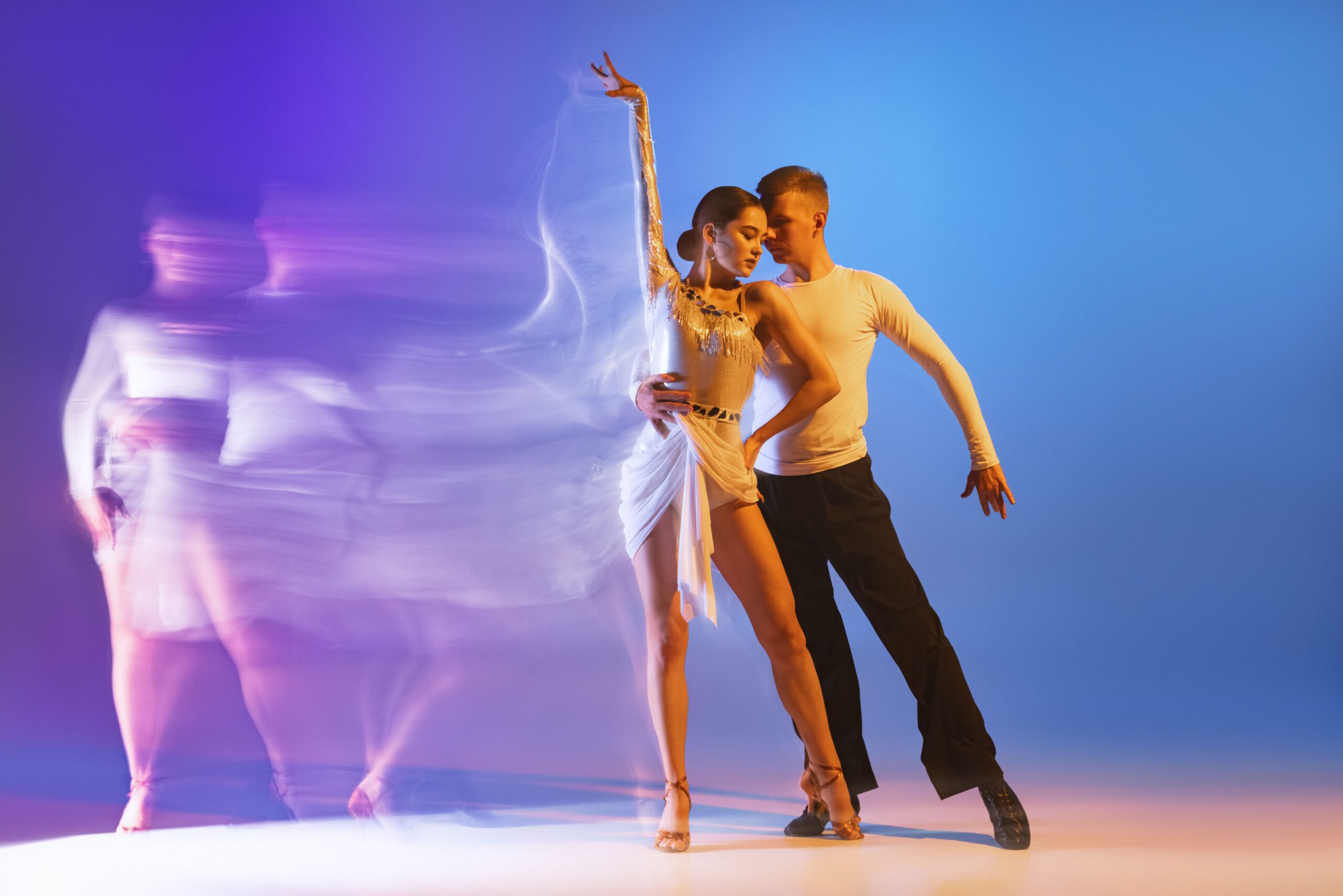 two-young-professional-dancers-training-isolated-gradient-blue-purple-wall-min